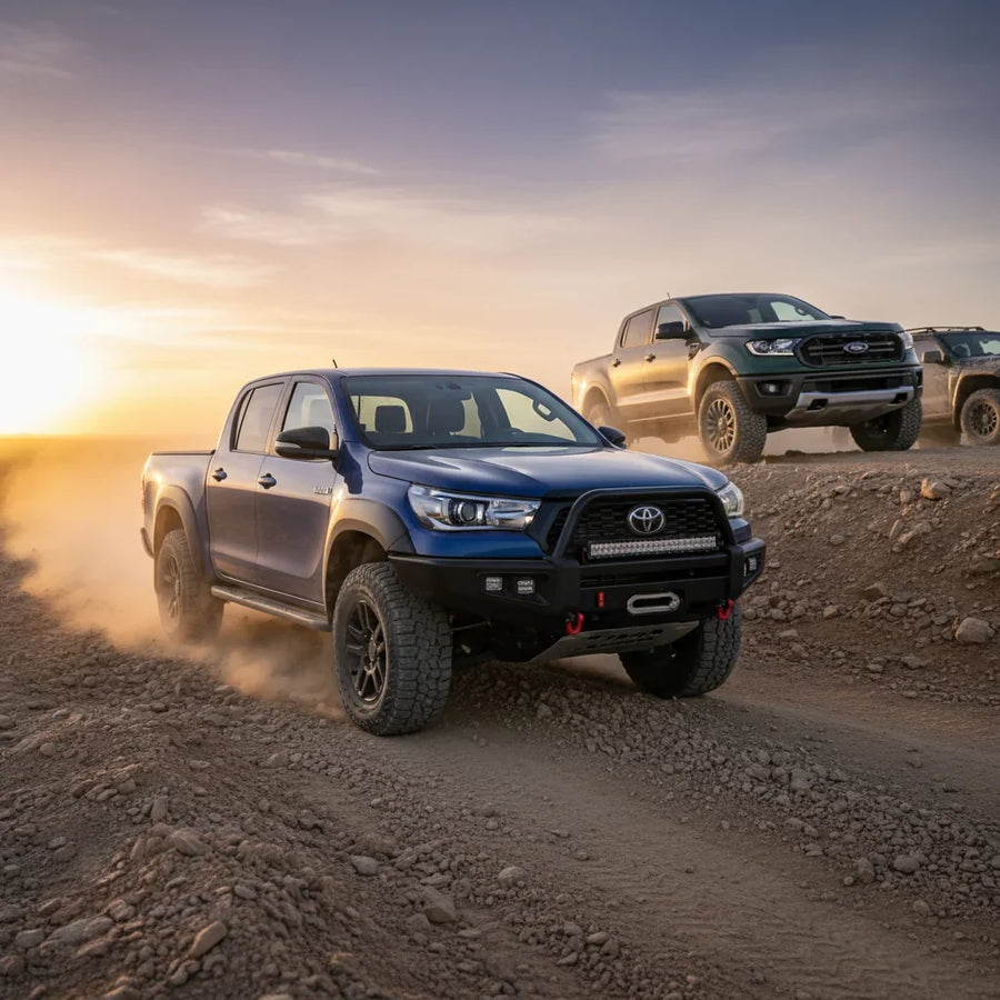 Editorial photo-realistic HERO image for automotive news (2026-05-19). Feature Toyota and Ford vehicles specifically HiLux, Ranger Super Duty. Scene: